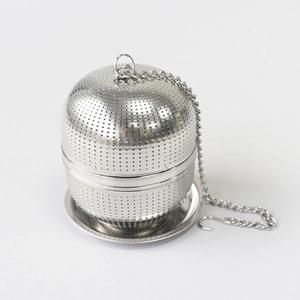Macro shot of 304 stainless steel ball tea infuser with chain and base on white background