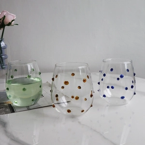 Detail of creative glassware with colorful raised dots in green amber and blue