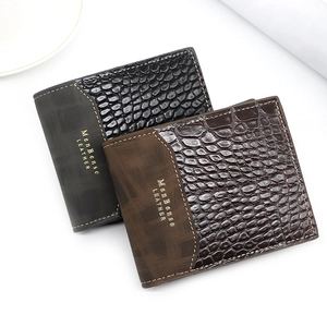 Detail shot of men's wallets featuring premium embossed crocodile texture and gold logo