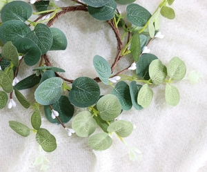 Detail shot of artificial eucalyptus vine with green leaves and white berries