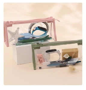 Detailed view of pink and green transparent PVC pencil cases with smooth zippers