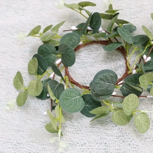 Close-up of artificial green eucalyptus leaves and brown stems on textured fabric