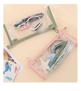 Flat lay of pink and green transparent PVC pencil cases showing storage capacity