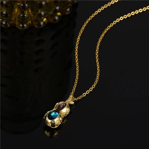 Titanium steel necklace with gold peanut pendant and blue and purple crystals on black background