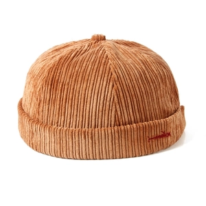 Vintage caramel brown corduroy docker hat with red embroidery and warm autumn texture