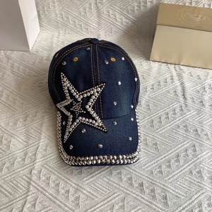 Detail of denim baseball cap featuring a large pearl star and silver metal rivets