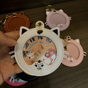 Close-up of cat-eared leather accessory bag with round PVC window and gold metal clasp