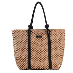 Large capacity hollow woven straw tote bag in light brown with black handles and straps