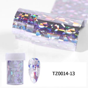 Detail of holographic silver nail foil roll with storage bottle and finished manicure effect