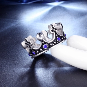 Macro shot of silver crown ring with blue gemstones and vintage black details