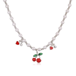 Close-up of cherry and heart charms on a pearl and silver bead jewelry necklace