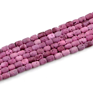 Macro shot of purple geode agate barrel beads with natural stone texture on white back