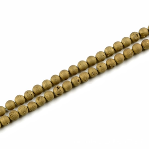 Macro shot of two strands of 10mm matte gold natural stone beads for DIY jewelry making