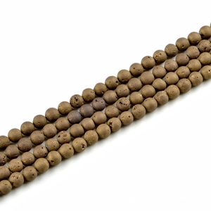 Macro detail of 10mm gold textured natural stone beads for handmade jewelry making