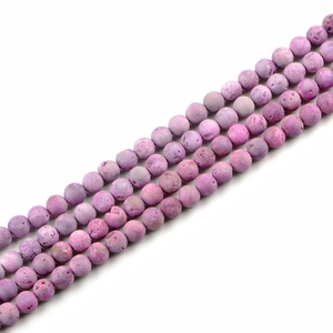 Macro detail of natural purple stone beads with matte porous texture for DIY jewelry