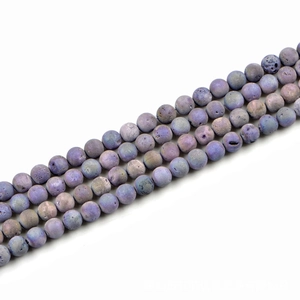 Macro shot of 10mm round purple natural stone beads with unique speckled patterns
