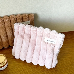 Fuzzy plush makeup bags in pink and brown with ribbed texture and woven label