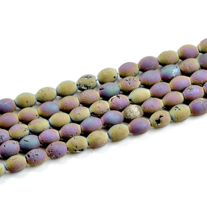 Macro view of purple and gold druzy agate drum beads with natural geode textures