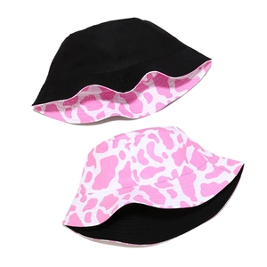 Pink and white cow print bucket hat with reversible black inner side for women
