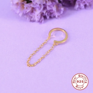 Macro view of minimalist 925 sterling silver ear cuff with chain on purple background