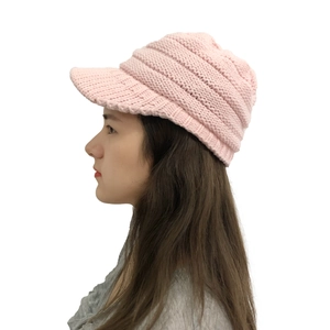 Detail view of pink knit winter hat with visor highlighting the thick yarn texture