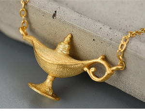 Macro shot of 925 sterling silver Aladdin lamp necklace with a matte gold brushed finish