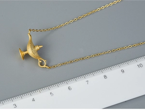 Macro shot of 925 sterling silver Aladdin lamp pendant in matte gold finish with scale