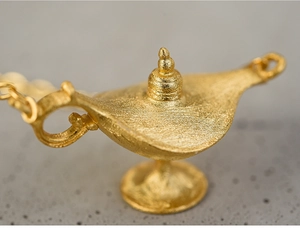 Macro shot of gold-plated Aladdin lamp pendant with a brushed matte texture on stone
