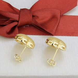 Close-up of 18k gold plated dome heart stud earrings with textured finish and cutout detail