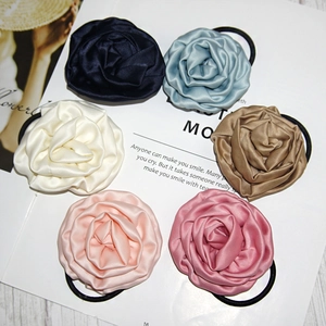 Detail view of champagne rose satin scrunchies in six elegant colors on a magazine background