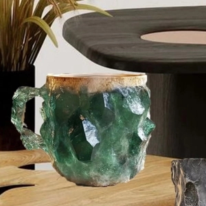 Detail of green crystal mineral coffee mug with gold rim on a rustic wooden table