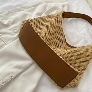 Chic woven shoulder bag with brown leather trim on minimalist white background