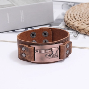 Detail of vintage brown leather bracelet with an antique bronze viking axe charm