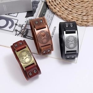 Three vintage braided leather bracelets featuring embossed tree of life metal plates