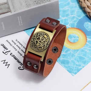 Macro detail of brown leather bracelet featuring Celtic knot and pentagram bronze plate