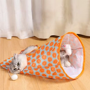 Detail of orange pattern cat tunnel with a plush toy ball and cat playing inside