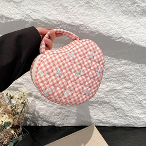 Handheld heart-shaped quilted pink plaid makeup bag featuring blue bow embroidery detail