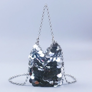 Detailed view of silver metallic fish scale sequins and fine chain strap on evening bag