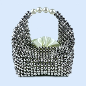 Close-up of silver beaded pillow bag featuring faux pearl handle and satin lining