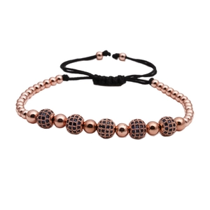Detail von Roségoldperlen und mikropavé Kristallkugeln am schwarzen geflochtenen Armband
