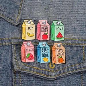 Set of six colorful fruit milk carton enamel pins featuring banana strawberry apple motifs