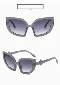 Cat eye sunglasses detail with wave-shaped temples and metal accents in grey frame