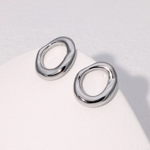 Macro detail of irregular silver geometric earrings with polished stainless steel finish
