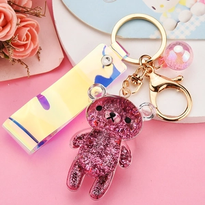 Macro shot of pink Rilakkuma shaker keychain with moving glitter oil and colorful strap