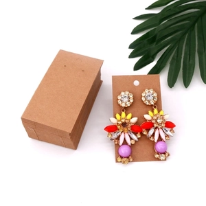 Detail of bohemian drop earrings with colorful beads and stones on a kraft display card