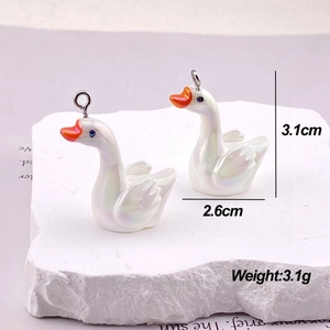 Detailed view of iridescent white swan charms with 3.1cm height and metal loops