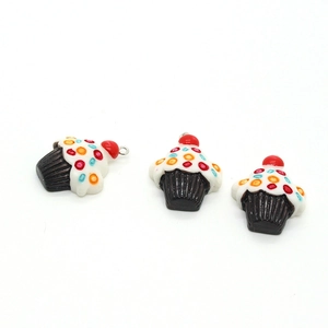 Macro detail of three fruit cupcake resin pendants with cherries on a white background
