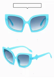 Macro view of bright blue cat-eye sunglasses with silver rivets and gradient lenses