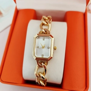 Elegant gold square quartz watch for women with diamond markers on a display pillow