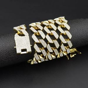 Close-up of gold iced-out Cuban link necklace and bracelet set on a dark jewelry stand